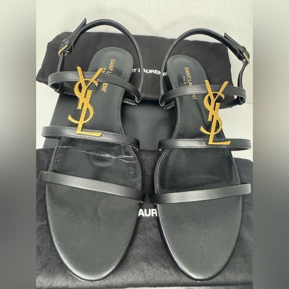 CASSANDRA LEATHER WITH GOLD EMBLEM HARDWARE IN BLACK SANDALS.